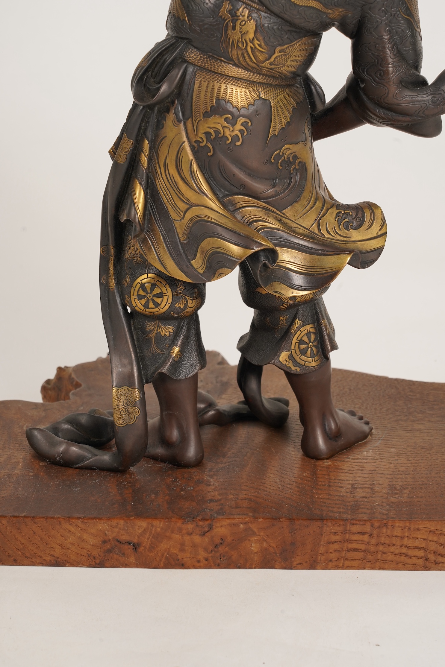 A large Japanese Miyao style parcel gilt bronze figure holding a koro aloft, 20th century